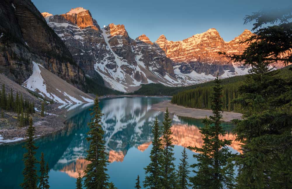 Moraine Lake, in the Valley of the Ten Peaks glowing pink in sunrise light
