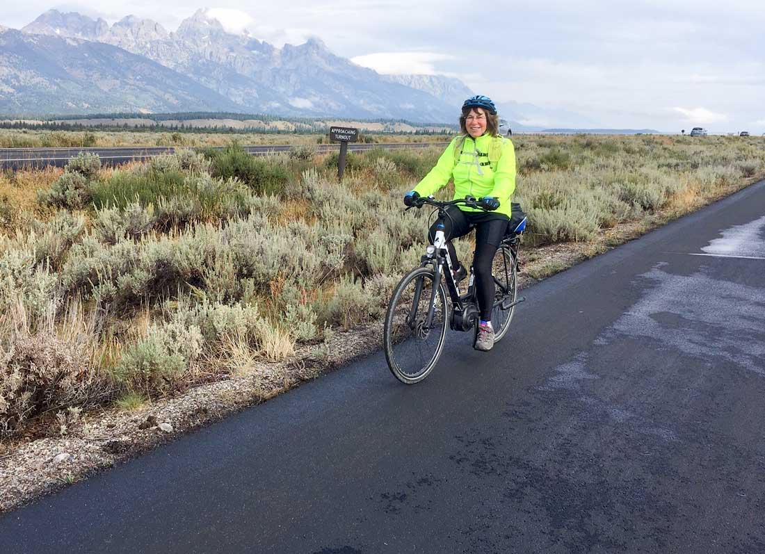 Author Ruth Edelman enjoys a ride on her e-bike with the Teton Mountains in the background.