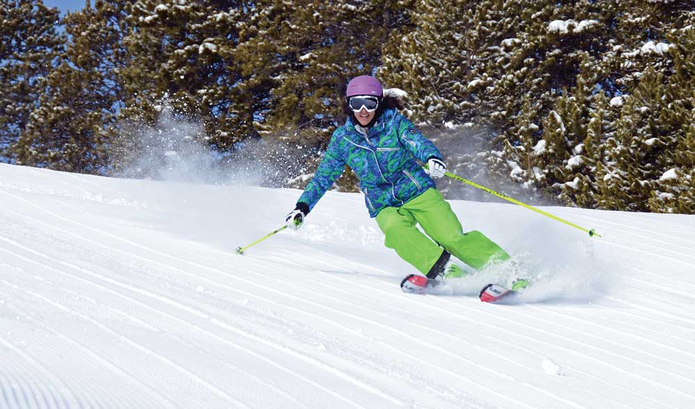author Lisa Ballard (left) arcs turns on a corduroy-groomed slope.