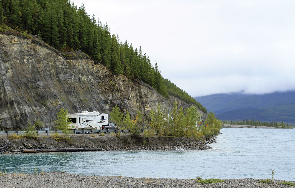 An RVer follows the shoreline of 7.5-mile-long Muncho Lake, a favorite stop for travelers on the Alaska Highway.