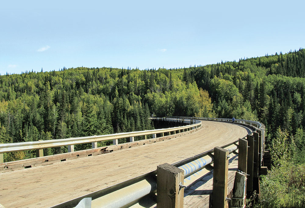 Curving 9 degrees along its 534-foot timber span, the Kiskatinaw Bridge is the only original Alaska Highway bridge still in use.