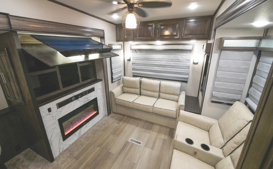 Cardinal Luxury 345RLX sofas and fireplace RV living area with electric fireplace inset in faux marble