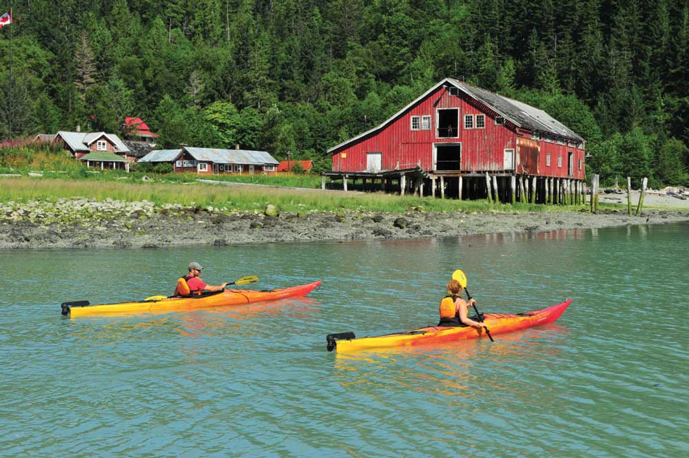Paddling a sea kayaks past the Tallheo Cannery, one of the few remaining fishing canneries on British Columbia’s Northwest coast.