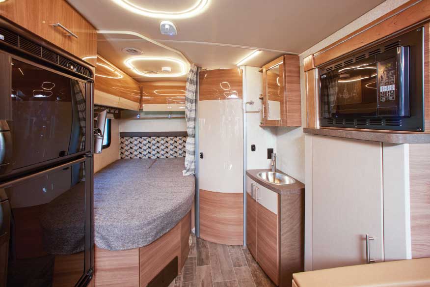  Bed is tucked in between the passenger-side wall and corner bathroom.