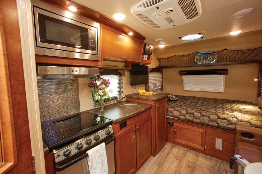 The 1475’s spacious galley features a clean look with a glass flush-mounted cover for the range, and attractive cabinetry and decor, including soffit LEDs.