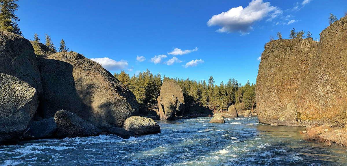 Churning river flanked by tall cliff faces.
