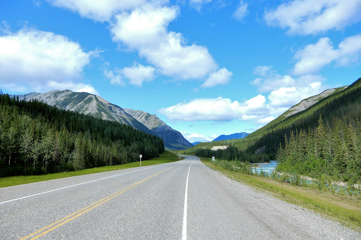 Highway stretches toward mountainous horizon.