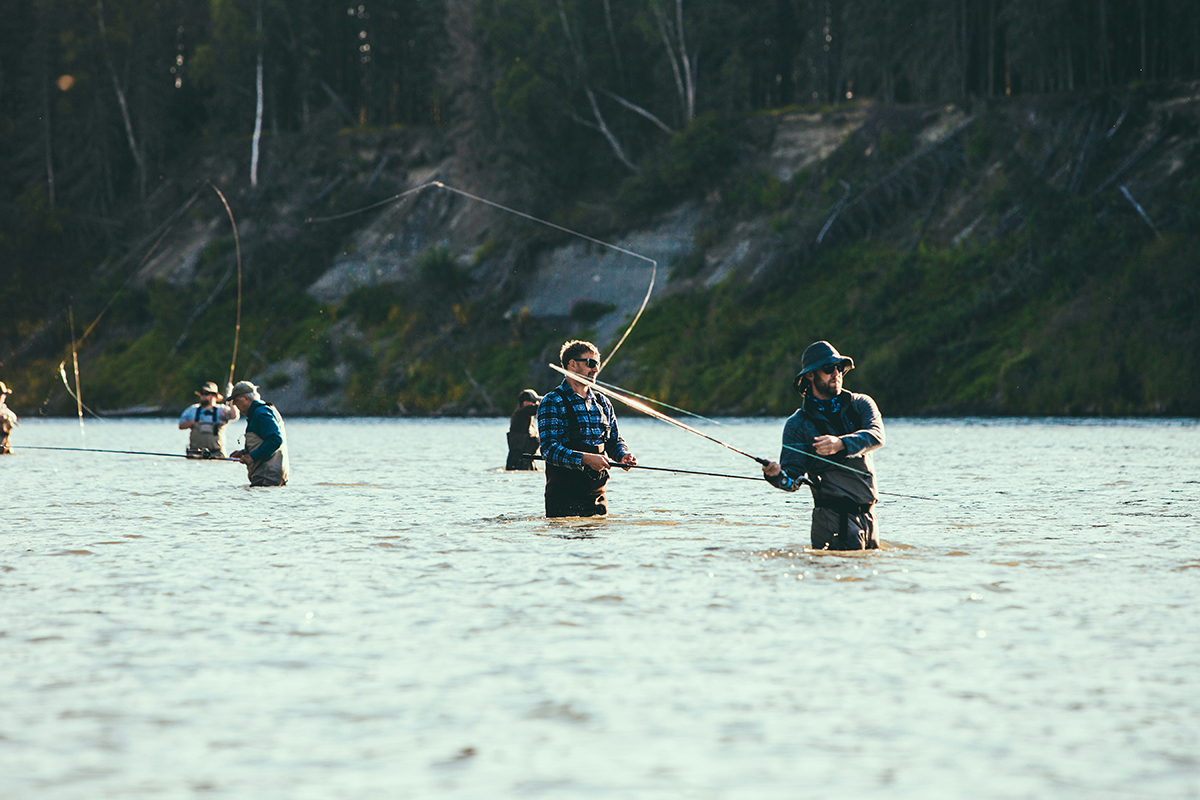 Anglers fly-fishing in a wide river.