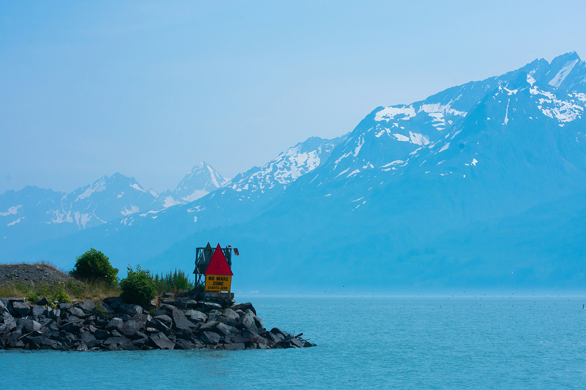 A jetty in foreground with mountains in background.