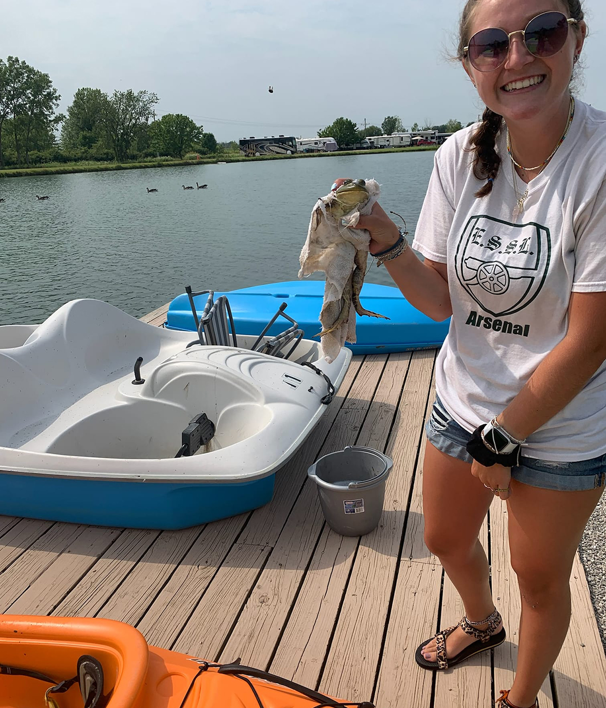 Woman on dock holding frog.