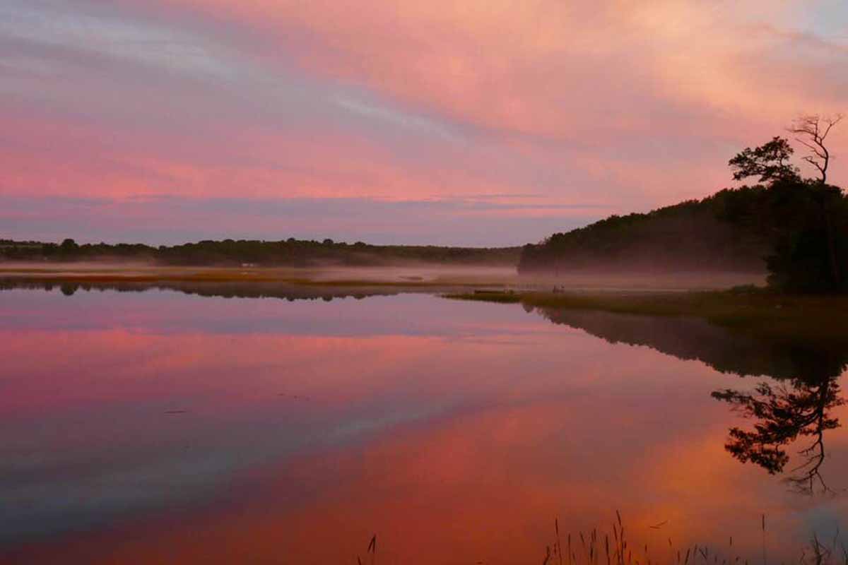 Shot of dusk sky reflected on smooth pond. 